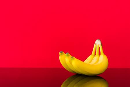 在光滑的表和红色背景上的新鲜香蕉