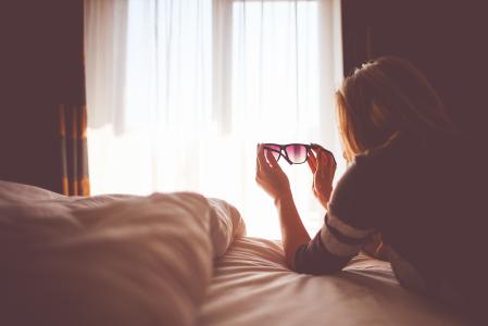 太阳镜在床上的女孩