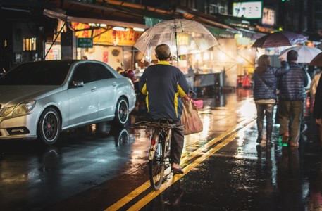 雨夜街头骑自行车的人