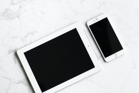 白色桌面上的平板电脑和手机