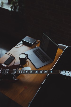 桌上的笔记本电脑和吉他