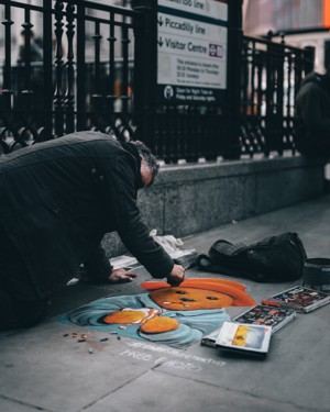 跪在街头画画的男子